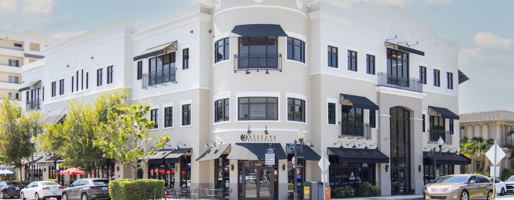 a white building with cars parked in front of it